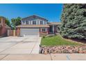 Exterior of a two-story home with blue siding, brick accents, an attached garage, and a landscaped front yard at 9442 W Walden Ave, Littleton, CO 80128