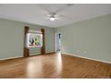 Bright, airy bedroom featuring hardwood floors, a ceiling fan, and large window at 23730 E Otero Dr, Aurora, CO 80016