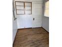 Small room with hardwood floors, window, and a door at 3816 W Dakota Ave, Denver, CO 80219