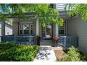 Inviting front porch with decorative columns and railing, complemented by lush landscaping at 13132 Pennsylvania Cir, Thornton, CO 80241