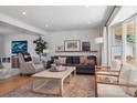 Bright living room with a neutral color palette, hardwood floors, large window, and stylish furniture arrangement at 4179 E Peakview Cir, Centennial, CO 80121