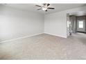 Spacious bedroom featuring neutral carpeting, ceiling fan, and ample natural light from the window at 2235 Alyssa St, Fort Lupton, CO 80621