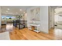 Entryway with wood floors, console table, painting and staircase leading to an open living area at 17637 W 87Th Ave, Arvada, CO 80007