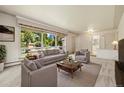 Bright and airy living room features a large picture window with views of trees and natural light, and neutral decor at 937 S Cole Dr, Lakewood, CO 80228