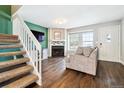 Cozy living room featuring wood floors, a fireplace, staircase, and an abundance of natural light at 17108 E Whitaker Dr # B, Aurora, CO 80015