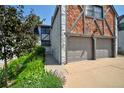 Charming townhome with a brick and white exterior, a two-car garage, and manicured landscaping at 5821 E Ithaca Pl, Denver, CO 80237
