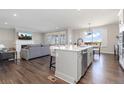 Open-concept living room and kitchen with a fireplace, hardwood floors, and abundant natural light at 11916 S Meander Way, Parker, CO 80138