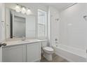 Modern bathroom featuring a shower over tub, white vanity, and a large mirror at 1321 Rock Cliff Ave, Erie, CO 80516