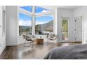 Bedroom showcasing large windows with mountain views and deck access, creating a serene and inviting space at 58 Stagecoach Blvd, Evergreen, CO 80439