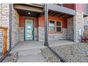 Inviting townhome entrance with a colorful door and stylish stone accents at 2849 E 103Rd Dr, Thornton, CO 80229