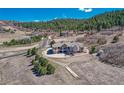 Beautiful home set against a backdrop of lush greenery and mountain views from a circular driveway at 1252 Rosewind Cir, Castle Rock, CO 80104