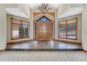 Grand foyer with soaring ceilings, a chandelier, and double wooden doors with stone accents at 1252 Rosewind Cir, Castle Rock, CO 80104