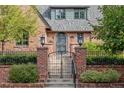 Close up of the front entrance of a brick home with wrought iron gate and a small flight of concrete stairs at 2825 E 9Th Ave, Denver, CO 80206