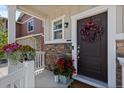 Close-up of the front door featuring a wreath, blooming flowers, and a charming covered porch at 5297 Blue Lunar Ln, Castle Rock, CO 80104