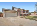 Charming two-story home featuring a well-maintained front yard and an attached two-car garage at 1207 S Memphis St, Aurora, CO 80017