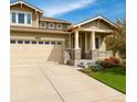 Inviting home with a two-car garage, stone accents and green lawn at 4850 Bluegate Ln, Highlands Ranch, CO 80130