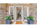 Inviting front entryway showcasing a stylish brick facade, potted plants, and a view of the interior staircase at 7567 Parkview Mtn, Littleton, CO 80127