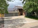 Modern house with solar panels, a spacious driveway, and a well-kept yard, perfect for sustainable living and curb appeal at 7567 Parkview Mtn, Littleton, CO 80127