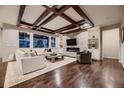 Open living room featuring a stone fireplace, built-in shelving, and a coffered ceiling at 6652 W Asbury Pl, Lakewood, CO 80227