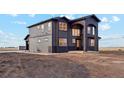 Modern two-story home features a stylish gray and black exterior with a unique arched entryway at 49601 E 56Th Ave, Bennett, CO 80102