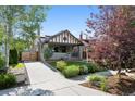 Inviting home with a well-manicured lawn, mature trees, and a concrete driveway at 815 S Gaylord St, Denver, CO 80209