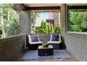 Cozy front porch with outdoor seating, a patterned rug, and brick accents at 815 S Gaylord St, Denver, CO 80209