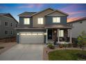 Charming two-story home featuring a well-maintained lawn, covered porch, and attached two-car garage at 9375 Joyce Way, Arvada, CO 80007