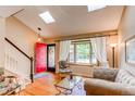 Bright living room with hardwood floors, large windows, and a welcoming red front door at 6687 Devinney Ct, Arvada, CO 80004