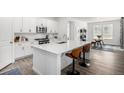 Bright kitchen featuring white cabinetry, quartz countertops, and a stylish breakfast bar at 8175 Sewanee Peak St, Littleton, CO 80125
