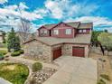 Beautiful home featuring stone accents, a spacious three car garage, and meticulously landscaped grounds at 7999 S Blackstone Pkwy, Aurora, CO 80016