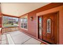 Charming front porch featuring stained-wood columns, a beautiful stained-wood door with glass inserts, and outdoor lighting at 7999 S Blackstone Pkwy, Aurora, CO 80016