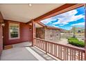 Covered porch with stone and wood details, offering a view of the neighborhood at 7999 S Blackstone Pkwy, Aurora, CO 80016