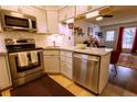 Bright kitchen featuring stainless appliances, white cabinets, and granite countertops at 10735 W Dartmouth Ave, Lakewood, CO 80227
