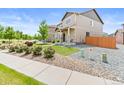 Charming two-story home with stone accents, a well-manicured lawn, and a beautiful array of decorative vegetation at 11684 Park South Loop, Parker, CO 80138