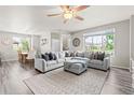 Bright living room with gray sectional, large windows, ceiling fan, and stylish decor at 11684 Park South Loop, Parker, CO 80138