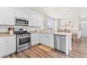 Modern kitchen with white cabinets, granite countertops, stainless steel appliances, and hardwood floors at 11684 Park South Loop, Parker, CO 80138