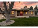 Charming single-story home boasts a well-manicured lawn and inviting red front door at 7039 Otis Ct, Arvada, CO 80003
