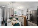 Kitchen with a dining area, green velvet chairs, and a modern light fixture at 17111 E Stanford Ave # C, Aurora, CO 80015