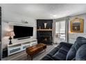 Living room with a fireplace, comfy couch, and a large TV at 17111 E Stanford Ave # C, Aurora, CO 80015