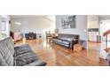 Spacious living room with hardwood floors, a leather couch, and a view to the dining area at 2325 15Th Ave, Longmont, CO 80503