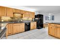 Well-lit kitchen boasts wood cabinets, black appliances and a brick backsplash at 26752 Vosler St, Conifer, CO 80433
