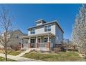 Beautiful two-story home featuring a covered front porch, fenced yard, and blossoming trees at 12881 Park Creek Way, Firestone, CO 80504