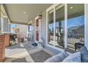 Cozy front porch with stylish decor, comfortable seating, and views of the neighborhood at 12881 Park Creek Way, Firestone, CO 80504