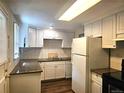 Efficient kitchen with granite countertops, tiled backsplash, and white cabinetry at 7331 Clay St, Westminster, CO 80030