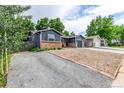 Cozy single-story home with driveway, brick accents, and gravel landscaping at 8696 W 86Th Cir, Arvada, CO 80005