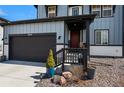 Inviting front porch with a red door, lush landscaping, and a spacious two-car garage at 6454 Leathers Ln, Parker, CO 80134