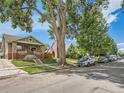 A charming brick bungalow with a well-maintained front yard on a tree lined street at 1615 Osceola St, Denver, CO 80204
