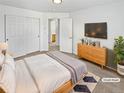 Well-lit bedroom features neutral paint, closet doors, access to bathroom, and modern furnishings at 3932 S Quatar St, Aurora, CO 80018