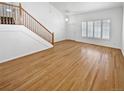 Unfurnished living room featuring light wood floors, neutral paint, and plenty of natural light at 3932 S Quatar St, Aurora, CO 80018