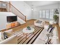 Bright living room showcasing a staircase, natural light, neutral paint, and tasteful decor at 3932 S Quatar St, Aurora, CO 80018